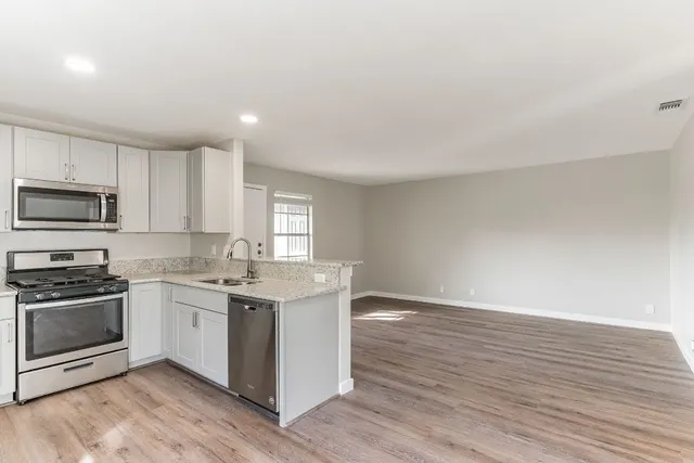 a kitchen with a sink cabinets and wooden floor
