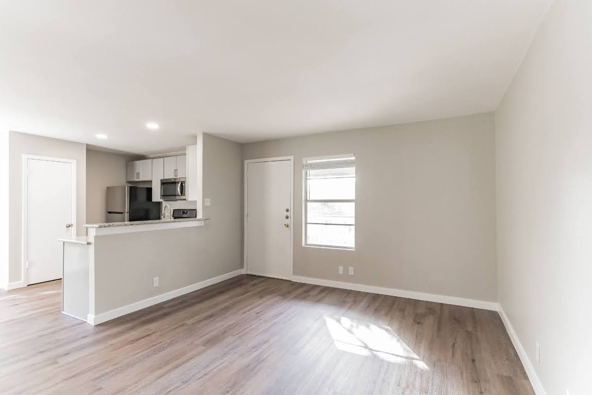 401 Hedgewood Drive, Unit D Georgetown, TX 78628 - Photo 6 of 19 wooden floor in an empty room with a window