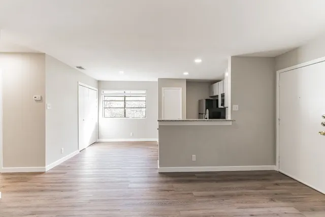 a view of a kitchen with wooden floor and a window
