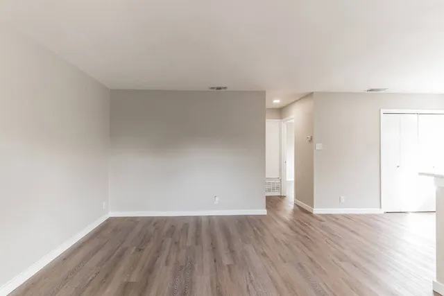 a view of an empty room with wooden floor