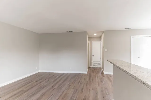 a view of an empty room with wooden floor