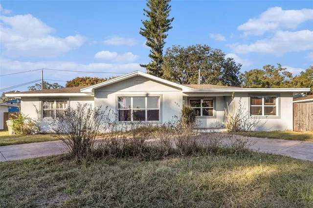 a front view of house with yard and trees around