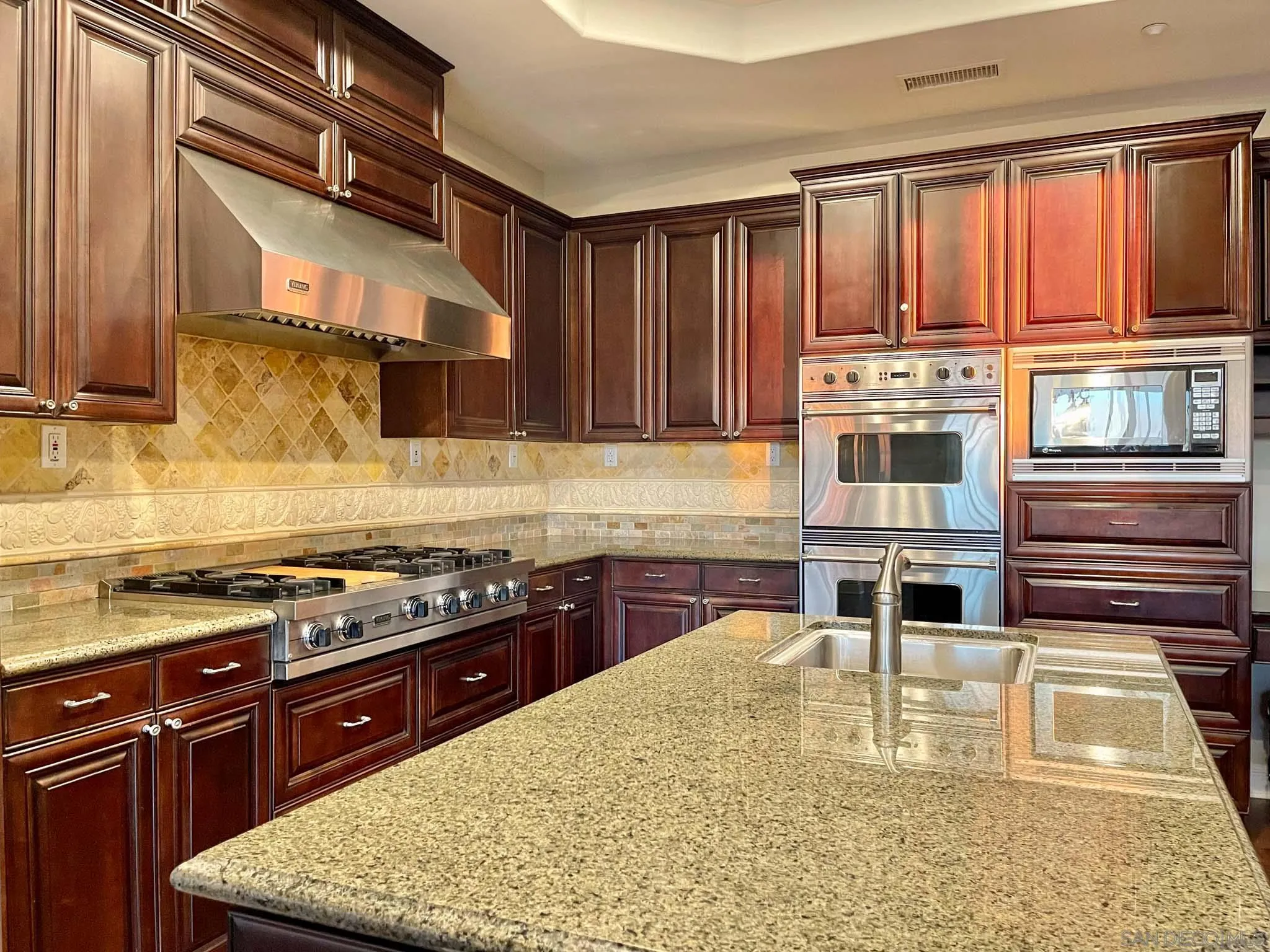 694 Cypress Hills Drive Encinitas, CA 92024 - Photo 17 of 49 a kitchen with stainless steel appliances granite countertop a stove a sink and a microwave