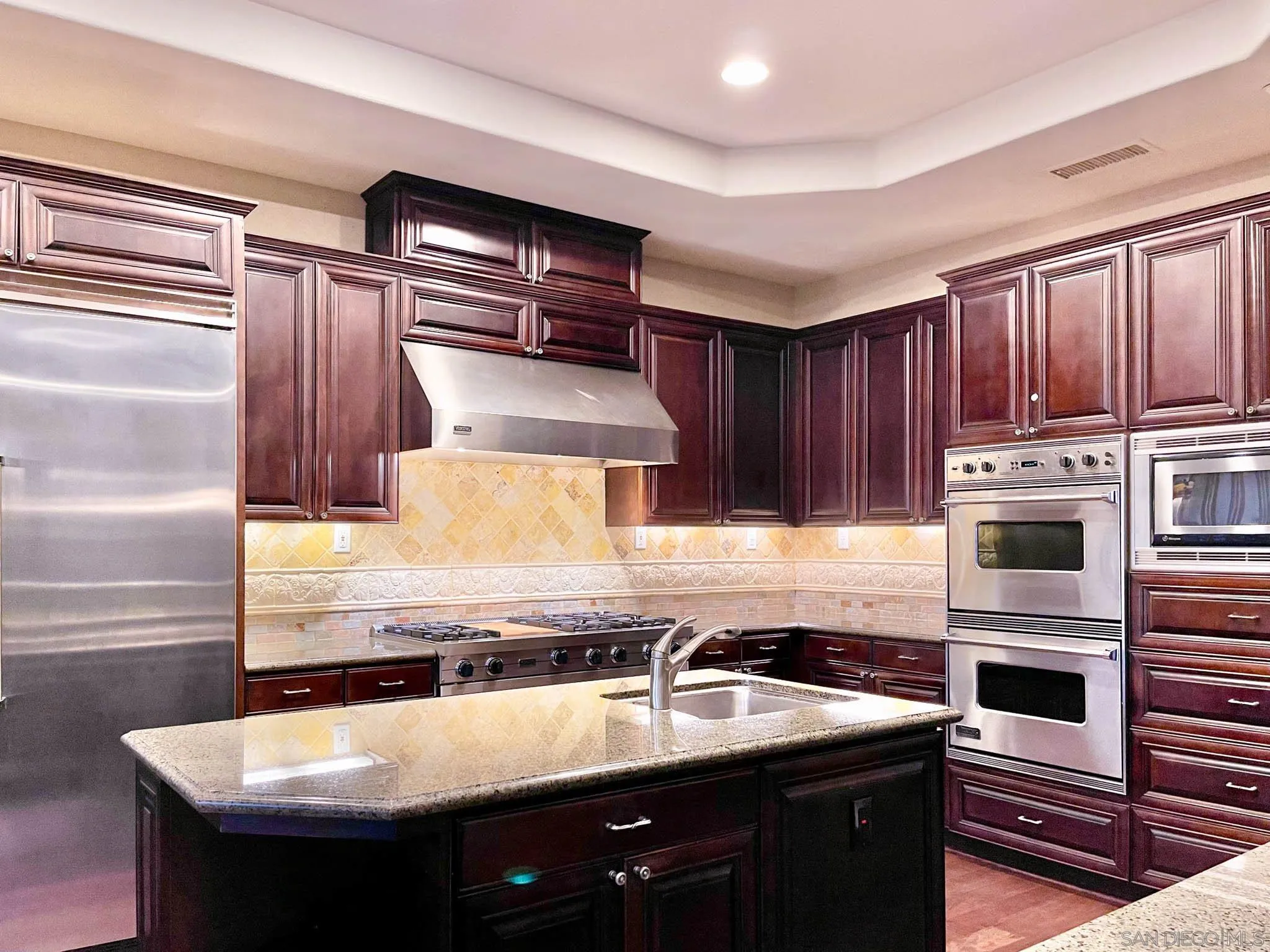 694 Cypress Hills Drive Encinitas, CA 92024 - Photo 21 of 49 a kitchen with kitchen island granite countertop wooden cabinets a stove and a sink
