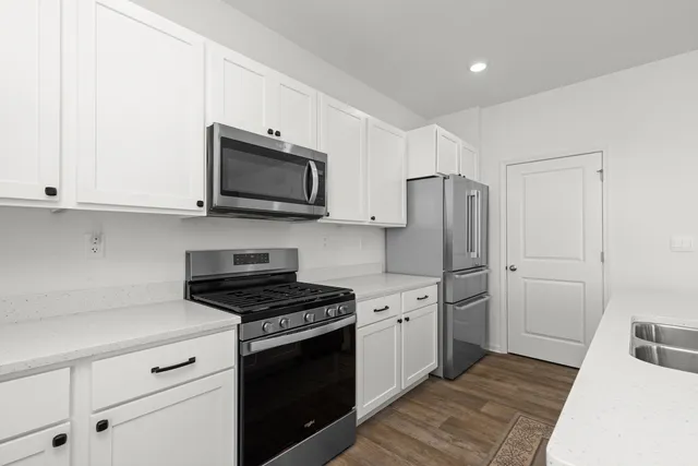 a kitchen with white cabinets and stainless steel appliances