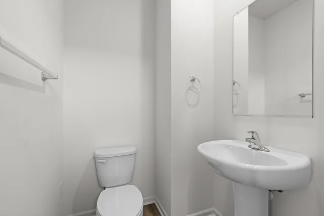 a bathroom with a sink toilet and a mirror