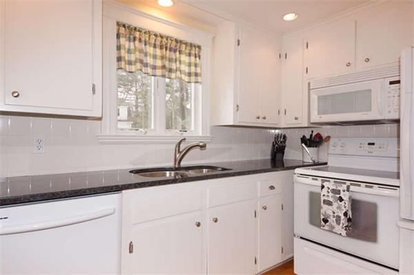 24 Colby Road Wellesley, MA 02482 - Photo 7 of 16 a kitchen with granite countertop white cabinets and window