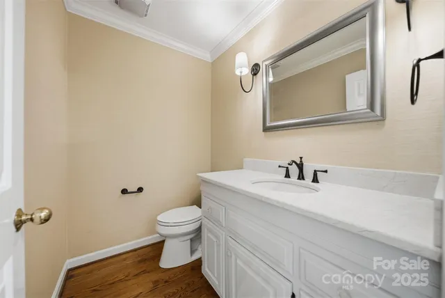 a bathroom with a granite countertop sink vanity mirror and toilet
