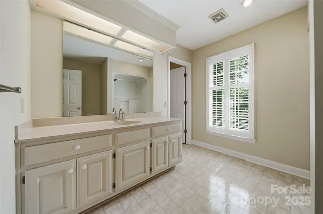 a spacious bathroom with 2 sink and a mirror