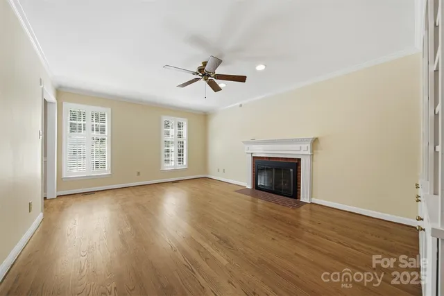 a view of empty room with wooden floor and fireplace
