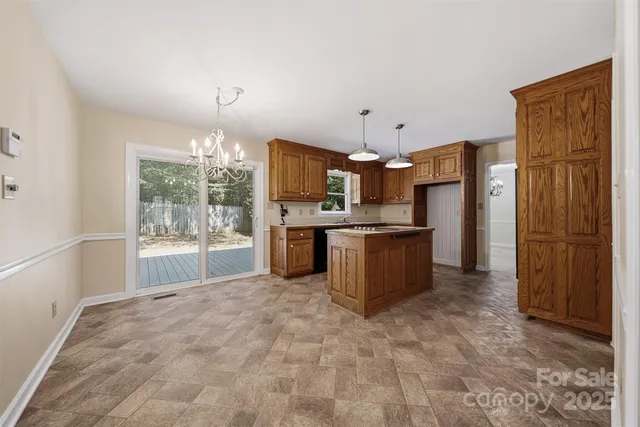 a kitchen with stainless steel appliances kitchen island granite countertop a refrigerator and a sink