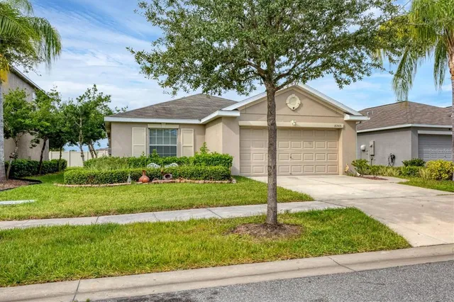 a front view of a house with a yard and palm trees