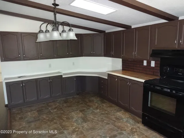 a kitchen with kitchen island granite countertop a stove and a refrigerator