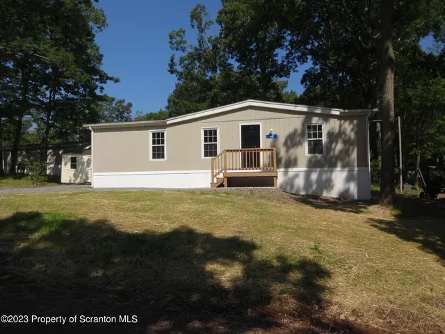 a front view of house with yard and trees