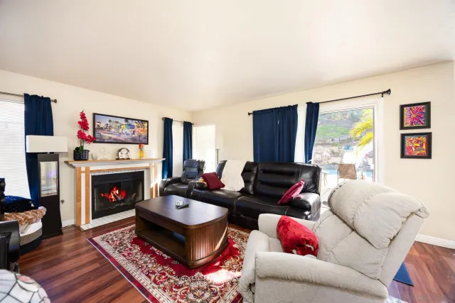 a living room with furniture a flat screen tv and a fireplace