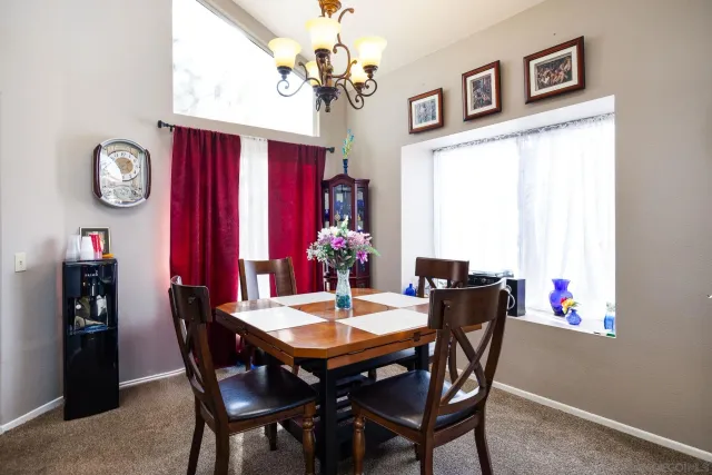 a view of a dining room with furniture and a chandelier