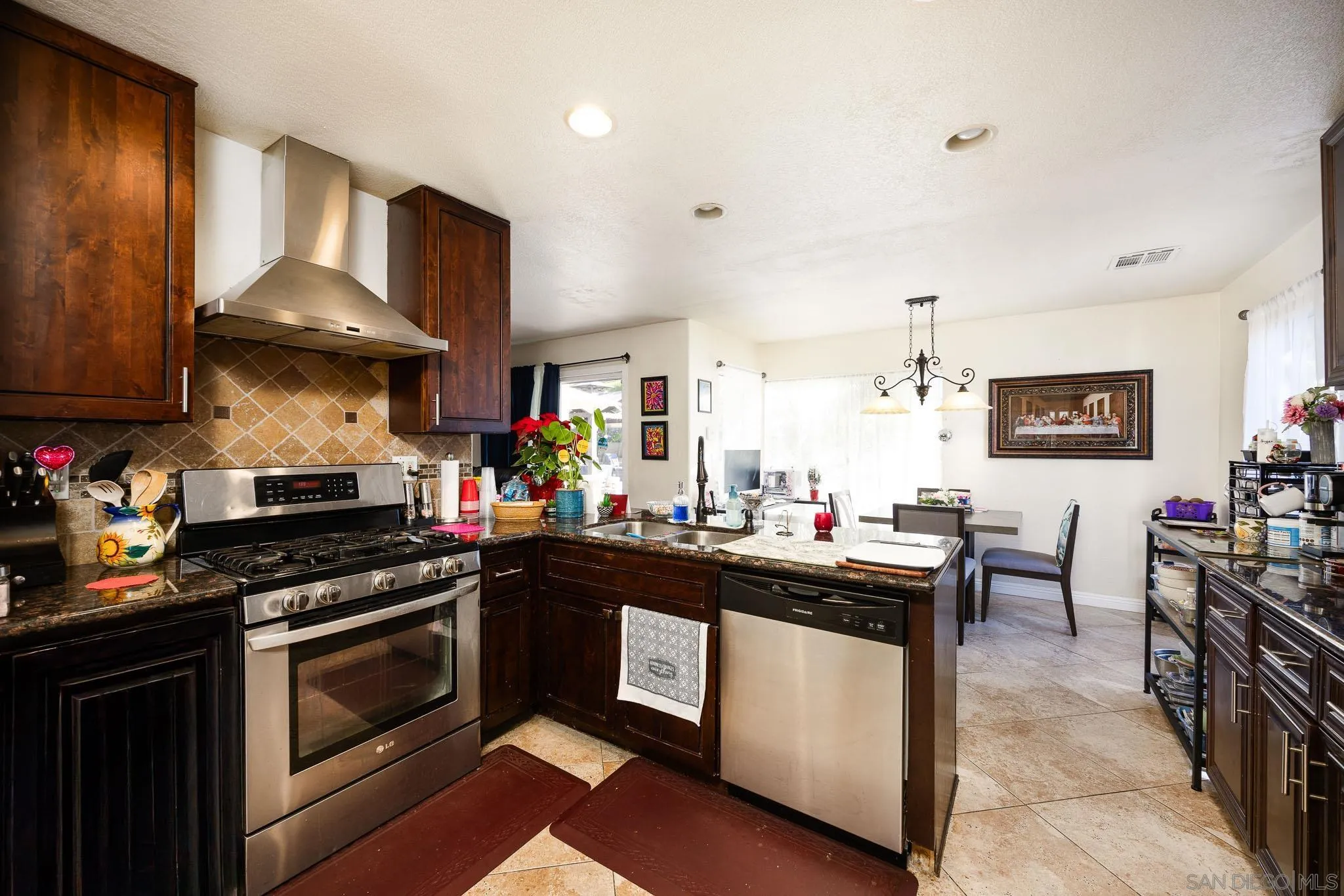 5063 Frazee Road Oceanside, CA 92057 - Photo 9 of 45 a kitchen with a stove sink and cabinets