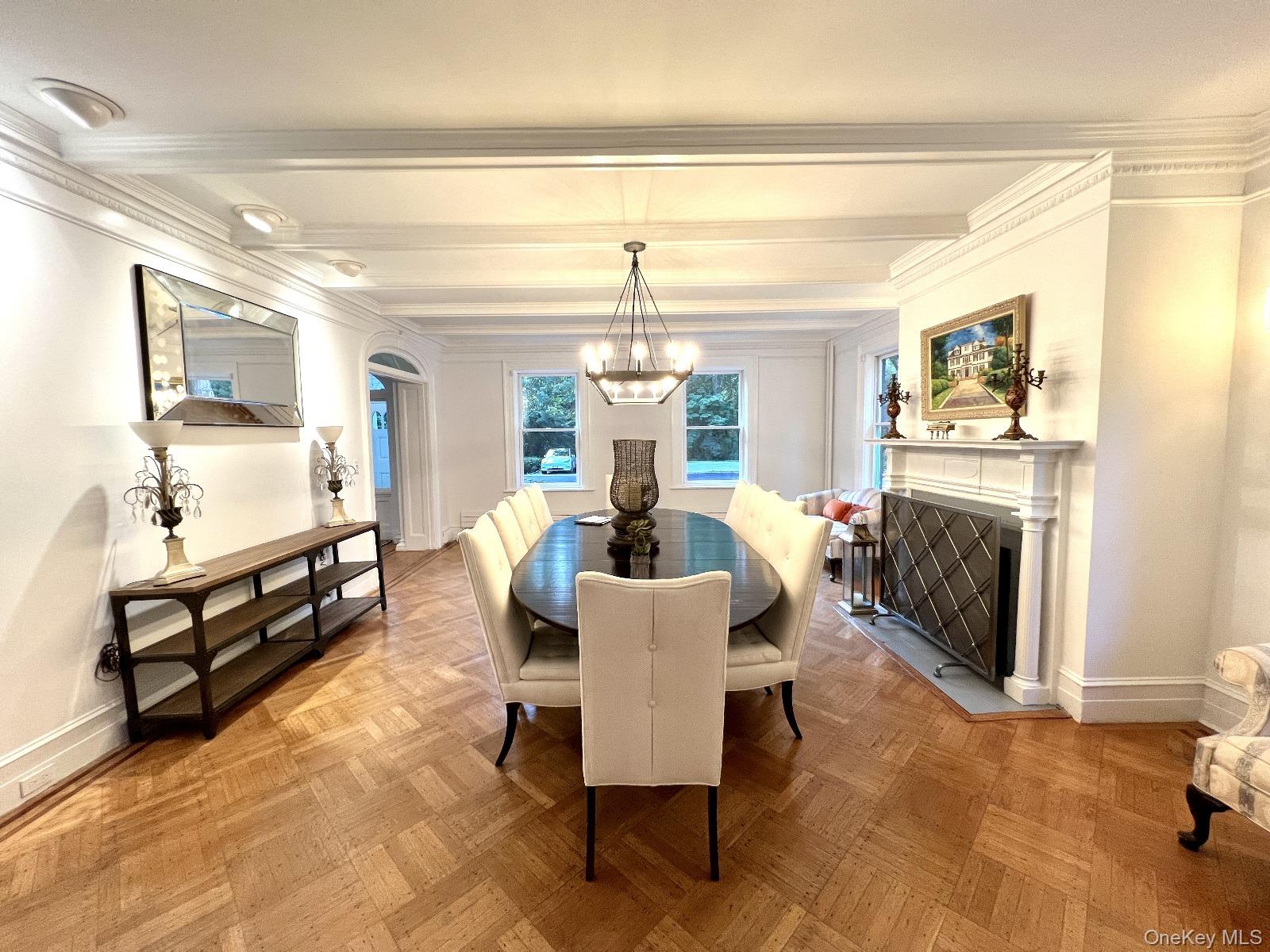 87 Wheatley Road Old Westbury, NY 11568 - Photo 15 of 16 Dining area featuring a chandelier, baseboards, ornamental molding, and beamed ceiling