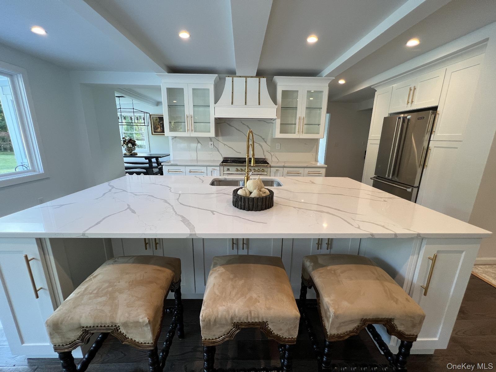 87 Wheatley Road Old Westbury, NY 11568 - Photo 7 of 16 Kitchen featuring high quality fridge, a sink, white cabinets, dark wood-style flooring, and a spacious island