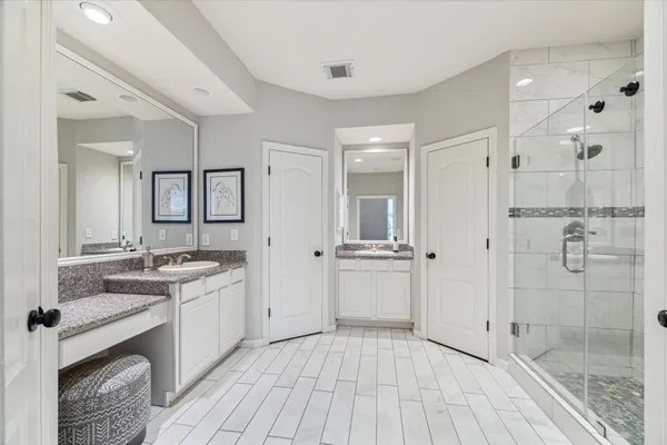 a bathroom with a granite countertop sink mirror and shower