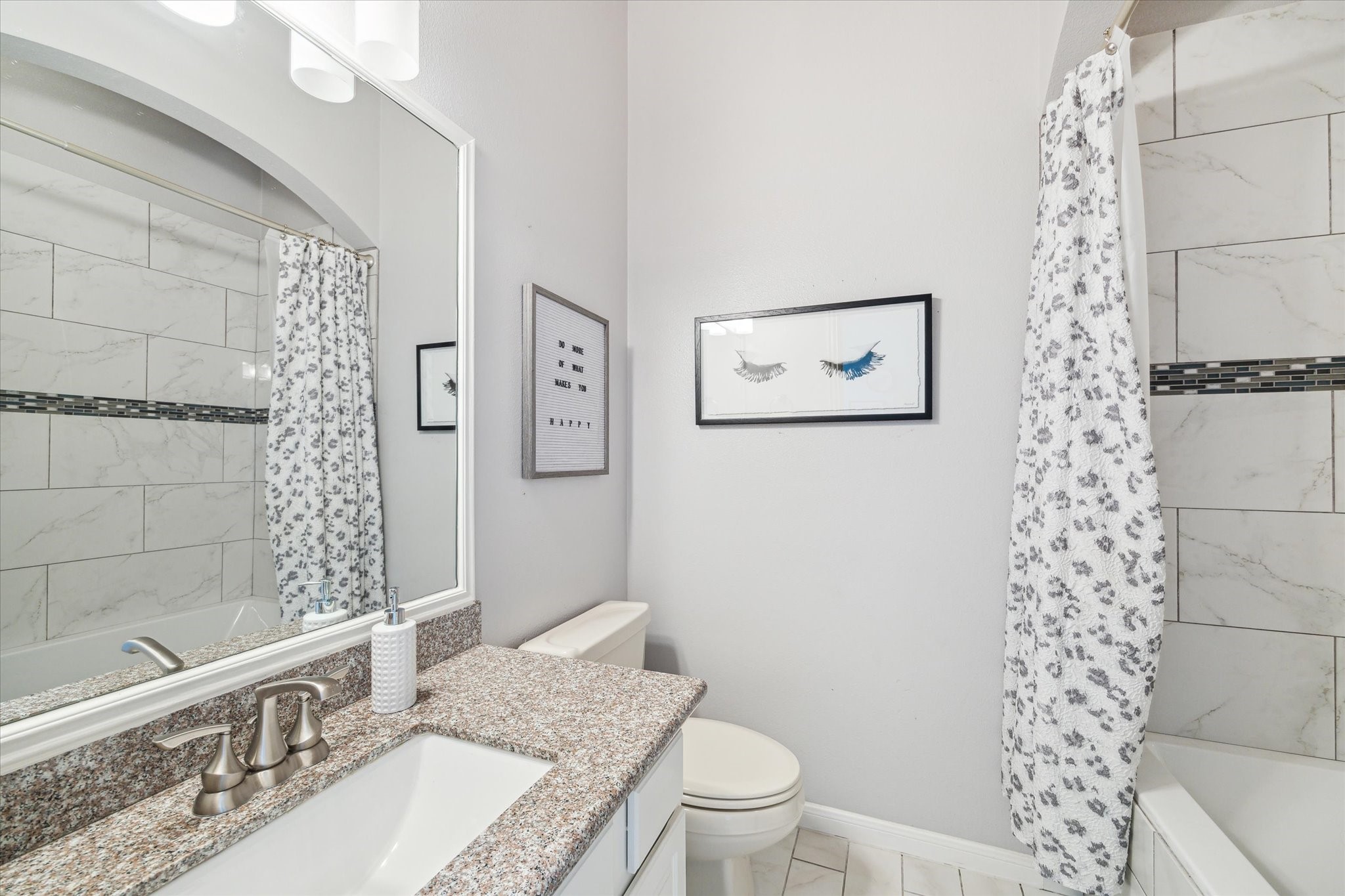 3310 Spring Landing Lane Pearland, TX 77584 - Photo 10 of 32 First Floor guest bath with updated lighting, granite counters, marble look tile flooring and oversized tub/shower with marble look tile surround.
