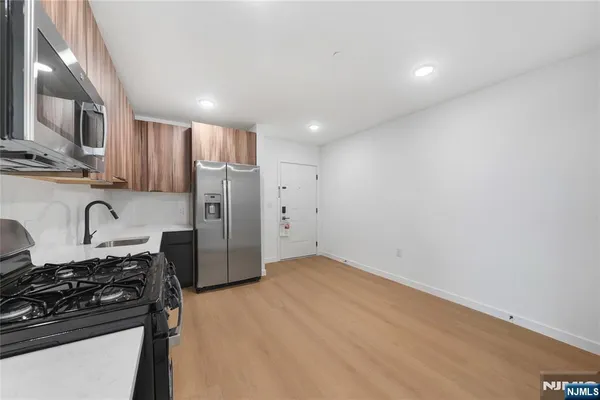 a kitchen with stainless steel appliances granite countertop a refrigerator and a stove top oven