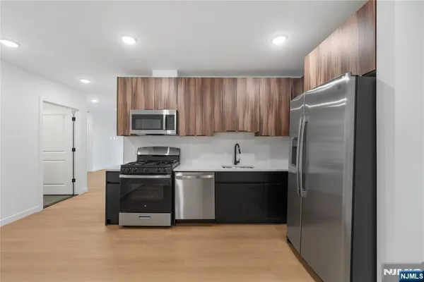 a kitchen with stainless steel appliances granite countertop a refrigerator and a stove top oven