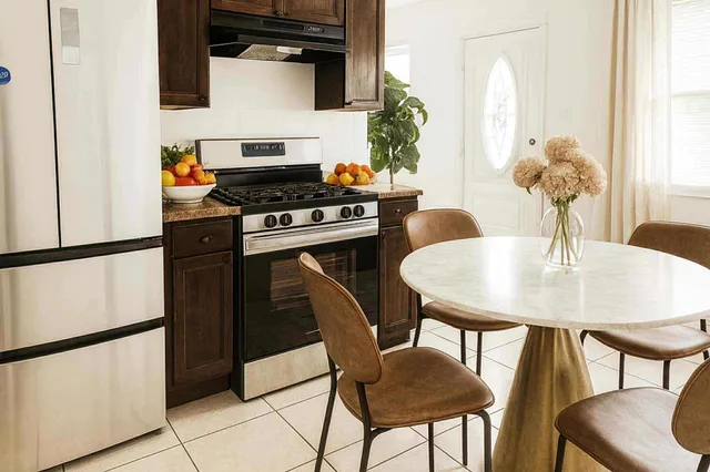 a kitchen with a table chairs and a refrigerator