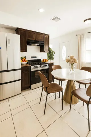 a kitchen with stainless steel appliances kitchen island granite countertop a table and chairs in it