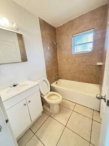 a bathroom with a toilet a sink a mirror and bathtub