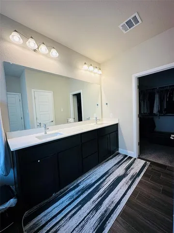 a spacious bathroom with a double vanity sink and a mirror