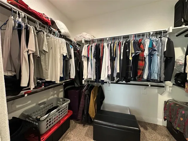 a view of walk in closet with clothes and shoes