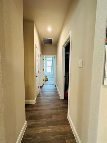 a view of a hallway with wooden floor and staircase