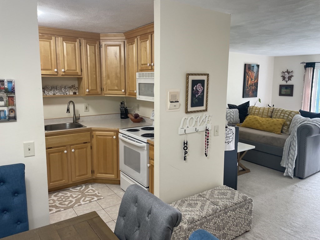 205 Great Road, Unit C8 Acton, MA 01720 - Photo 14 of 34 a kitchen with stainless steel appliances granite countertop a refrigerator and a stove top oven