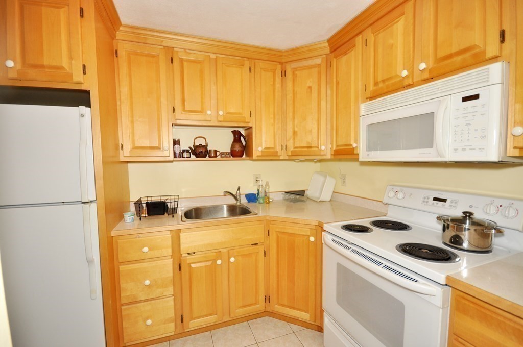 205 Great Road, Unit C8 Acton, MA 01720 - Photo 2 of 34 a kitchen with a sink a stove and a refrigerator