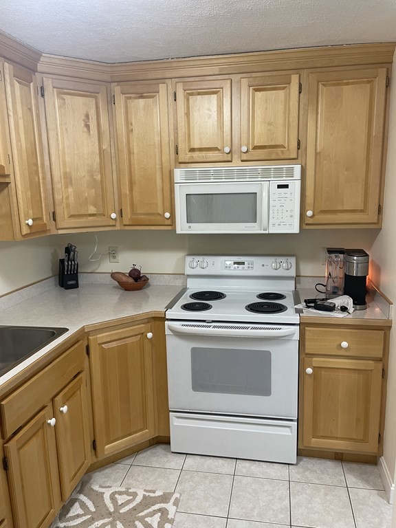 205 Great Road, Unit C8 Acton, MA 01720 - Photo 21 of 34 a kitchen with granite countertop cabinets stainless steel appliances and a sink