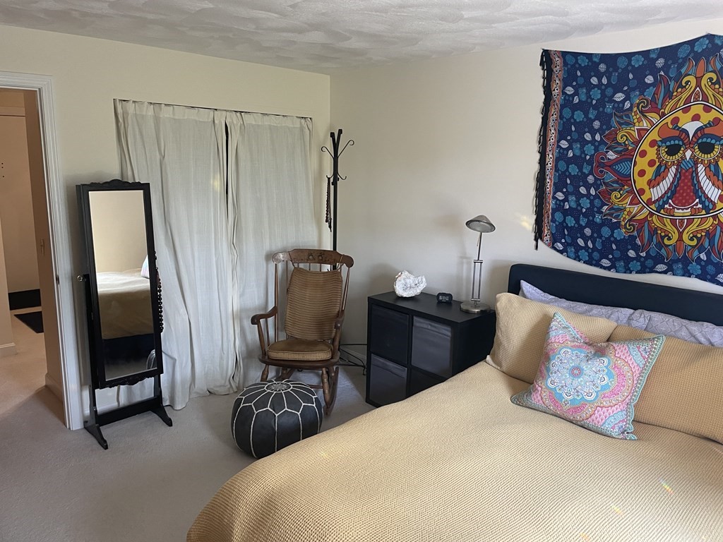 205 Great Road, Unit C8 Acton, MA 01720 - Photo 24 of 34 a bedroom with furniture and a painting on the wall