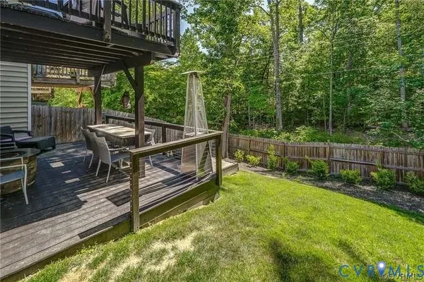 a view of backyard with deck and outdoor seating