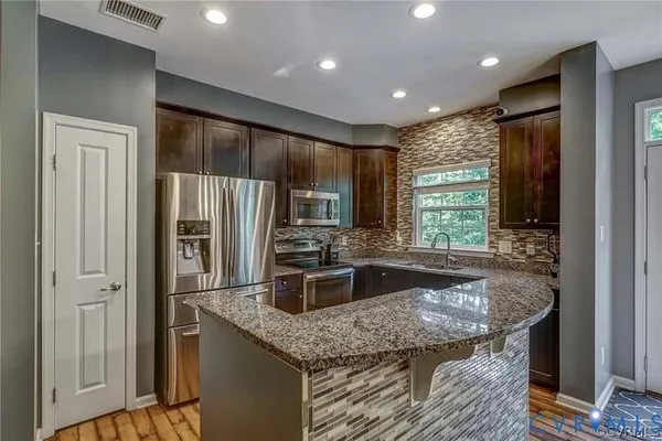 a living room with granite countertop furniture and a flat screen tv