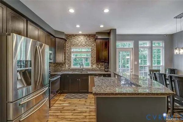 a kitchen with granite countertop a sink stove and microwave