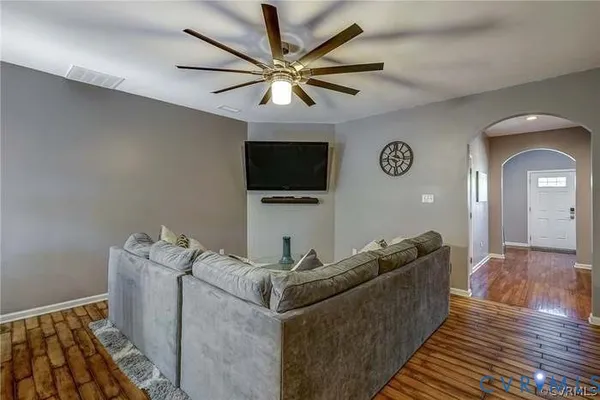 a hallway with wooden floor windows and a bathroom