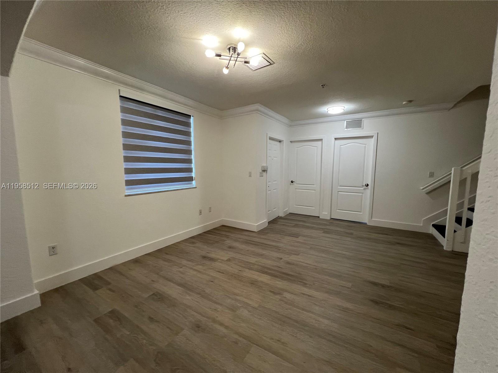 8001 West 36th Avenue, Unit 1 Hialeah, FL 33018 - Photo 25 of 48 a view of empty room with wooden floor and fan