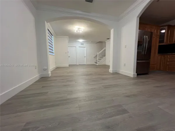 a view of an empty room with wooden floor