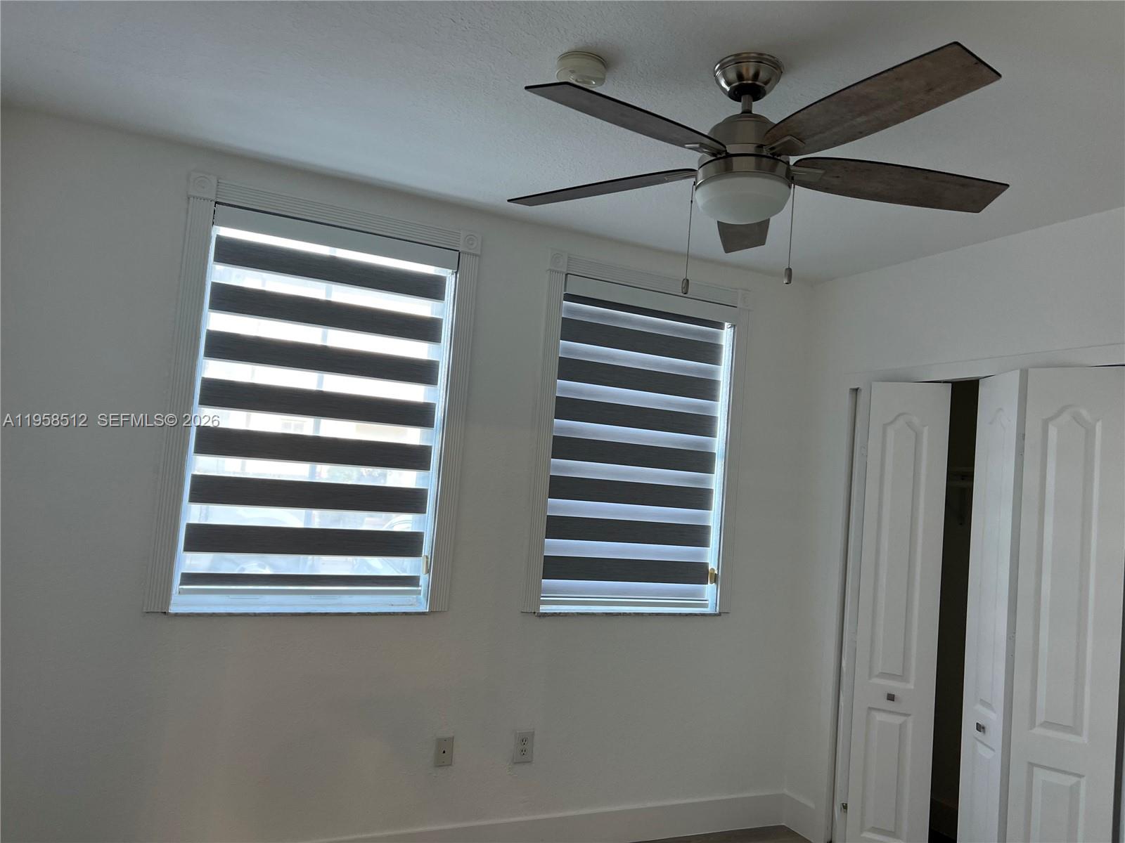 8001 West 36th Avenue, Unit 1 Hialeah, FL 33018 - Photo 30 of 48 a view of a bedroom with a window and a ceiling fan