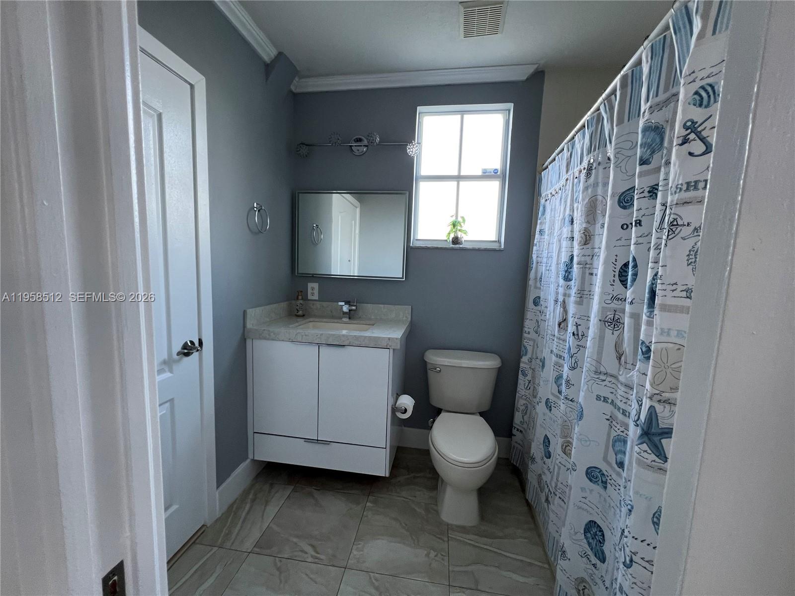 8001 West 36th Avenue, Unit 1 Hialeah, FL 33018 - Photo 31 of 48 a bathroom with a toilet sink and a mirror