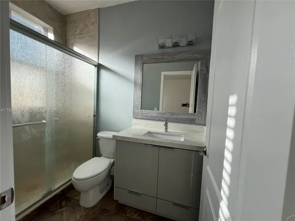 a view of empty room with wooden floor and window