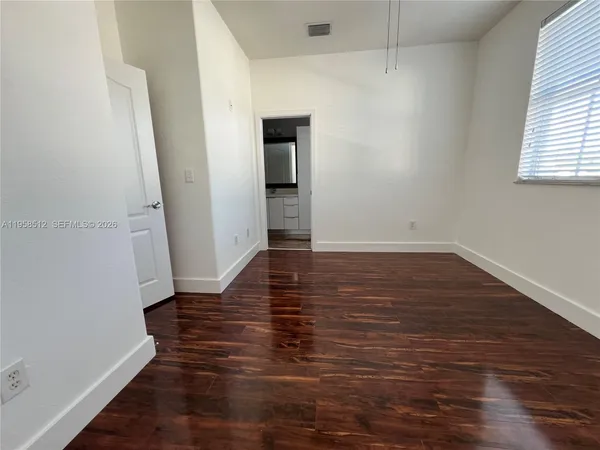a view of empty room with wooden floor