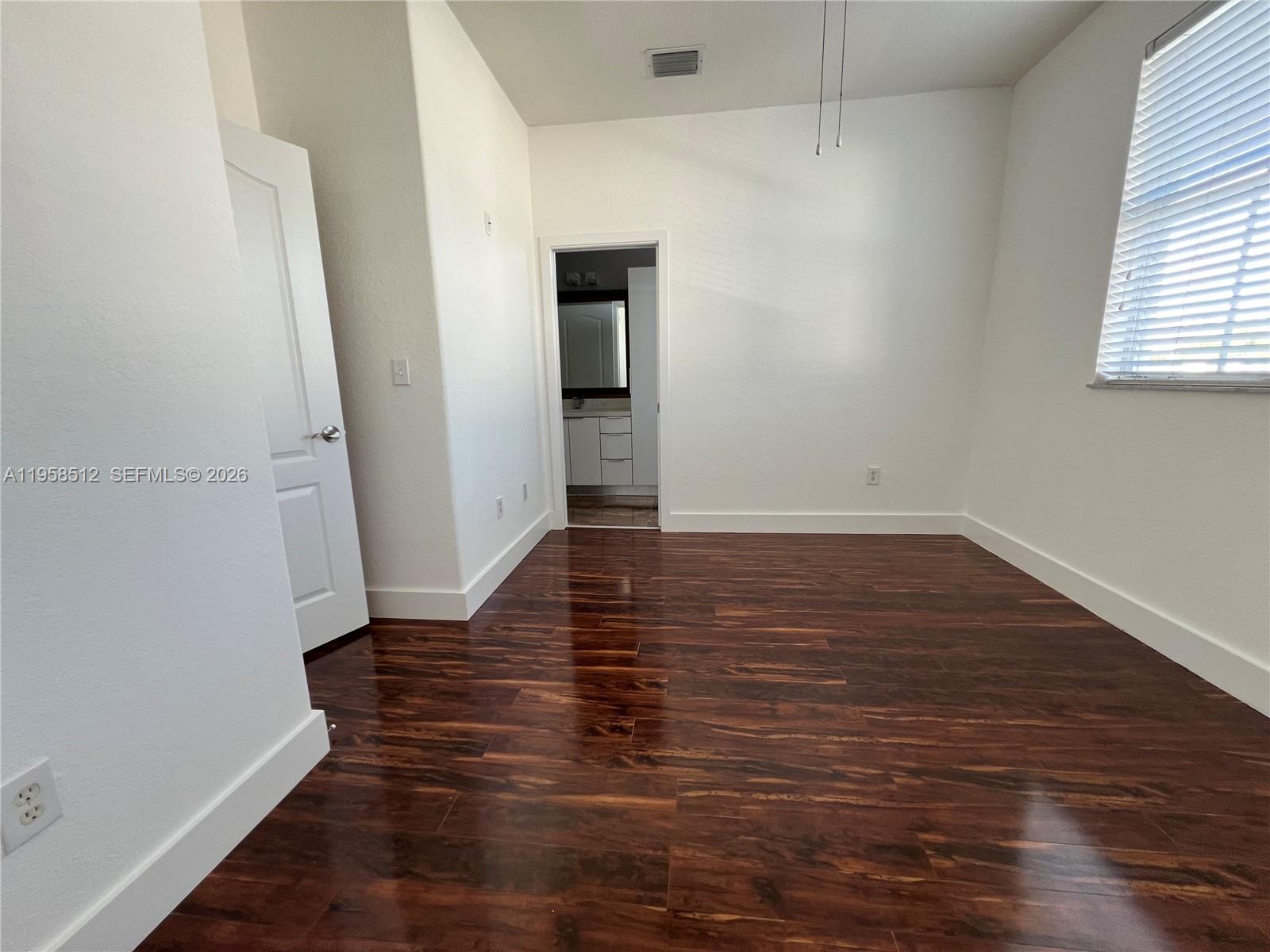8001 West 36th Avenue, Unit 1 Hialeah, FL 33018 - Photo 39 of 48 an empty room with wooden floor and windows