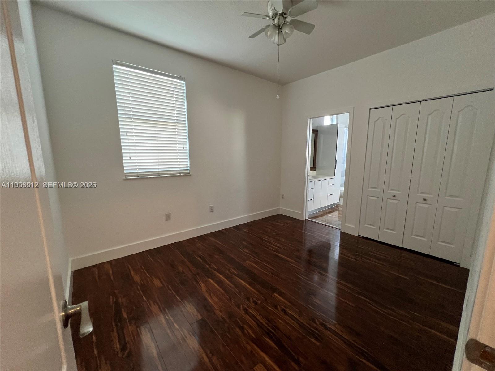 8001 West 36th Avenue, Unit 1 Hialeah, FL 33018 - Photo 41 of 48 an empty room with wooden floor closet and windows