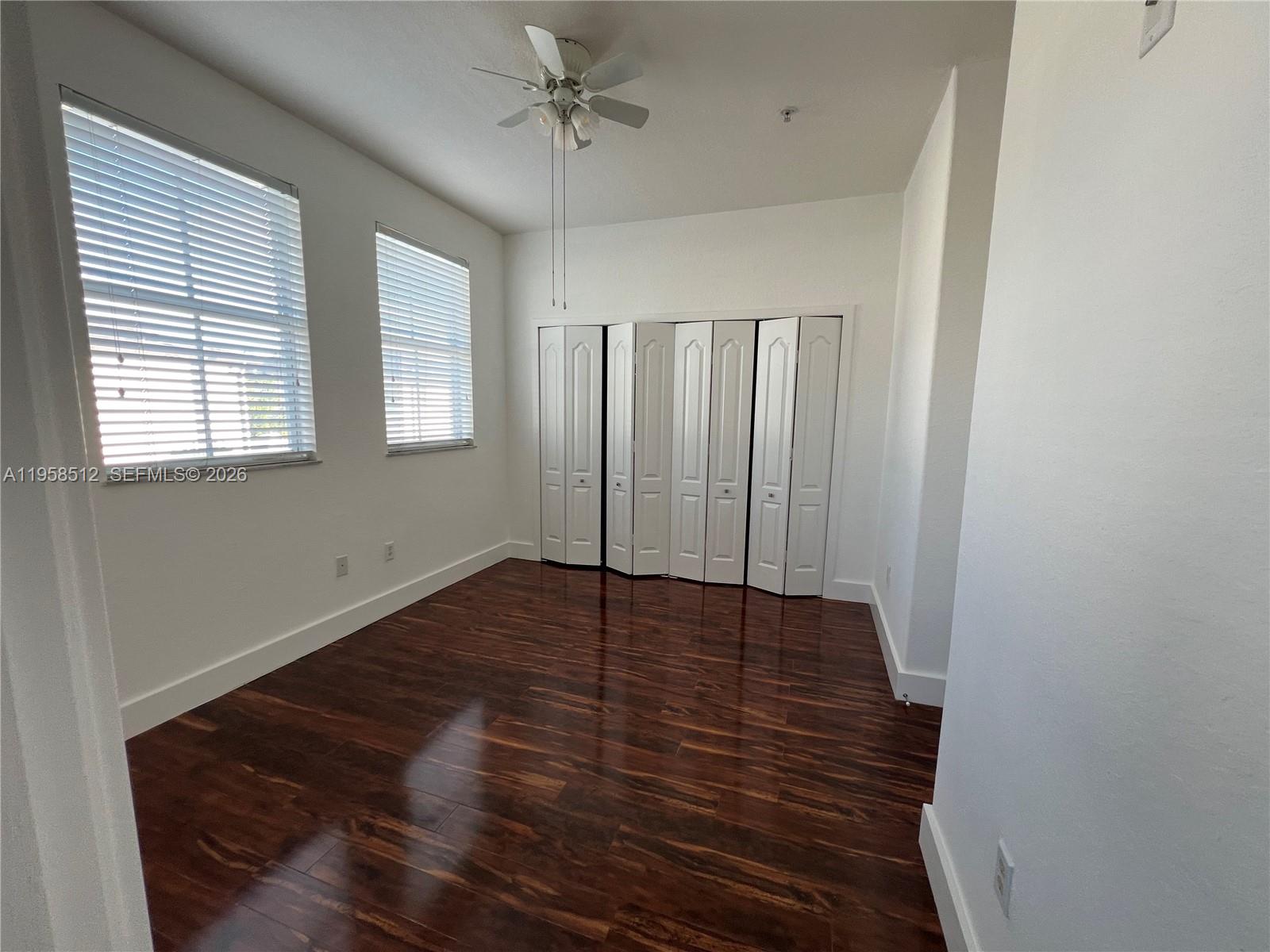 8001 West 36th Avenue, Unit 1 Hialeah, FL 33018 - Photo 42 of 48 a view of an empty room with wooden floor and a window